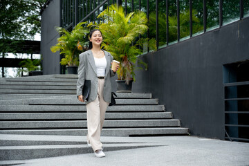 Asian businesswoman in a stylish suit is walking down the stairs