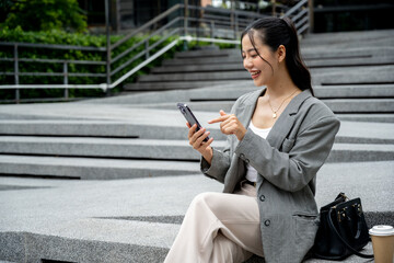 Asian businesswoman reading messages or replying to chats on her smartphone