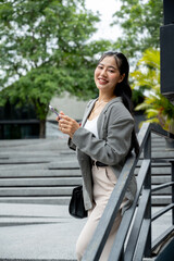 Asian businesswoman reading messages or replying to chats on her smartphone