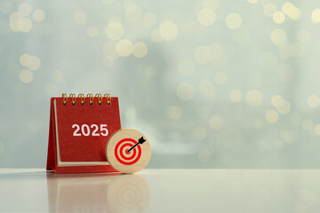 Happy New Year 2025 and goals. Target icon on a round wood block and white 2025 number on red small...