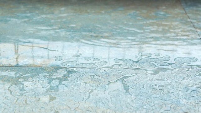 Wet surface on floor with water pooling from rainwater.