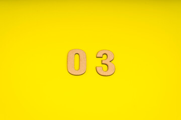 Number zero three in leather on yellow background