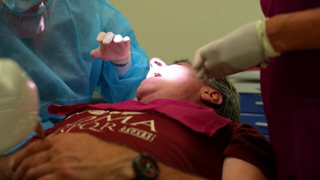 Dentist fixes denture screws during dental implant operation
