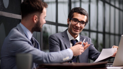 business colleagues sitting at a desk in a modern office