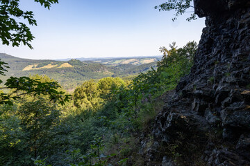 Rocky viewpoint to summer landscape under blue sky