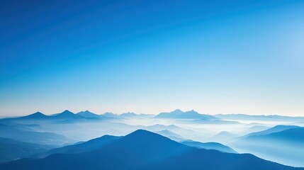 Fototapeta premium Blue Mountains and Sky Wallpaper. A serene landscape wallpaper with a distant mountain range bathed in blue hues under a clear sky.