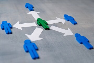 A green figure at the center surrounded by blue figures with arrows. Delegation concept. Green...