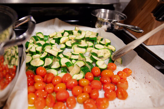 Close-up of roasted cherry tomatoes and zucchini on a baking tray