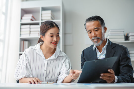 Businessman holding a clipboard and explaining business strategy to his colleague during a meeting