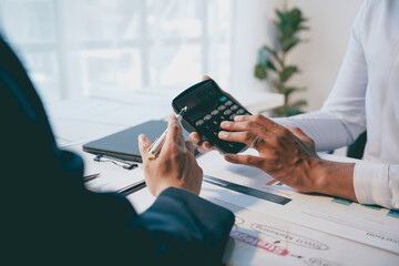 Business team working together, analyzing financial documents and using calculator in the office