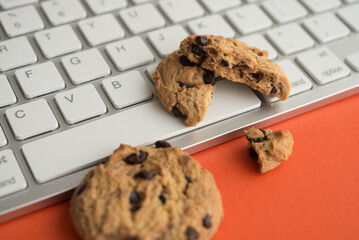 Broken chocolate chip cookies on keyboard computer background. Cookies website internet homepage...
