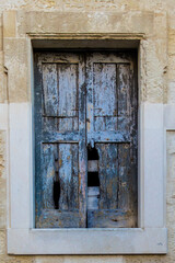Dettaglio di una vecchia finestra di legno sulla facciata di una casa di Lecce, in Salento