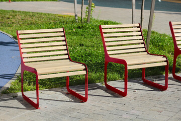 Modern street benches on the sidewalk in the yard.