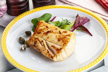 Roasted cod fish steak with salad