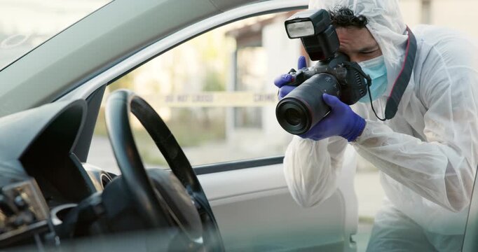 Forensic photographer, car and investigation in street for crime, hijacking and evidence for police. Man, camera and outdoor on road with inspection, accident and ppe suit by stolen vehicle in Sydney