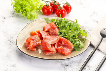 Sliced salmon with fresh arugula