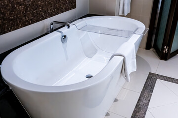 Modern minimalist bathroom interior, modern bathroom cabinet, white sink, wooden vanity, interior plants, bathroom accessories, bathtub and shower, white and beige walls, concrete floor.