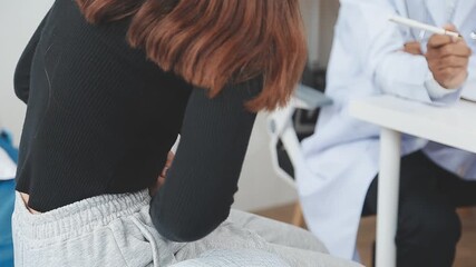 Patient suffering from stomach ache while consulting doctor in clinic