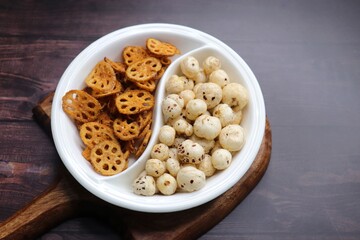 Crispy lotus stem chips and roasted makhana, perfectly spiced and golden brown, offer a delightful crunch and unique flavor. Ideal for healthy snacking or as a gourmet appetizer. kurkuri Kamal kakdi. 