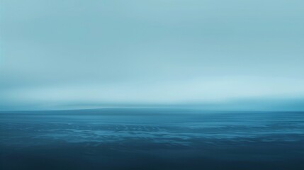 Fototapeta premium A blue ocean with a cloudy sky in the background