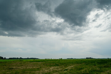 Gęste ciemne chmury deszczowe wiszące nisko nad ziemią  © Paweł Kacperek