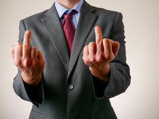 A man in a suit and tie with his middle fingers gesture. Concept of professionalism and authority....