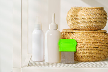 Bottles of Lice Treatment Products and a Comb on a Countertop