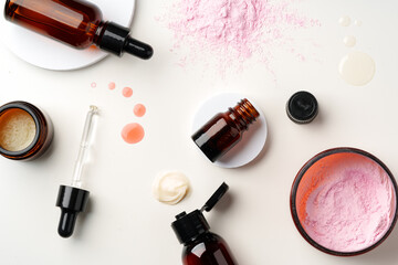 Assorted Skincare Products and Powder Spilled on a White Background