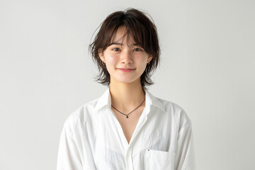 Fototapeta premium casual portrait features a young woman with straight hair and a soft smile, highlighted by a crisp white shirt and a bright, clean background.