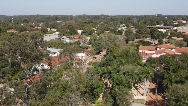 Aerial view of the city or town, surrounded by many trees and white buildings, around the central park.