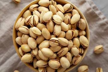 Roasted and Salted Pistachios in a Bowl on a gray background, top view.