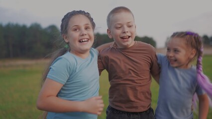 team children hugging jumping shouting rejoice success. happy family kid dream concept. a group of children embraced in nature in the park play jump hug together. lifestyle teamwork concept
