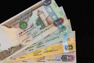 United Arab Emirates currency notes dirhams on back background. Close up with selective focus.