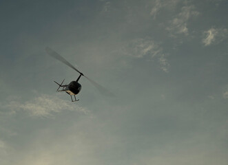lecący helikopter nad płytą lotniska o zachodzie słońca na tle nieba © siwyk