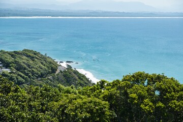 Clear lines of waves in perfectly clear water. Surfers in the water in front of Wategos Beach, Byron Bay, Australia. Most Easterly Point of the Australian Mainland. Surfer's paradise spot. 
