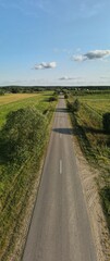 Drone view of the highway road, forest and fields, top view and blue sky