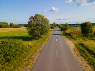 Drone view of the highway road, forest and fields, top view and blue sky