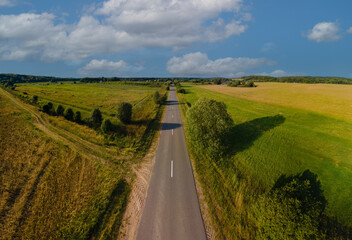 Drone view of the highway road, forest and fields, top view and blue sky