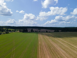 Drone view of the highway road, forest and fields, top view and blue sky