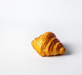 A small croissant, freshly made, on a white background, a common pastry in any cafe