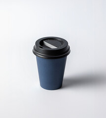 Mockup of a small empty blue cardboard cup, with black cap, on a white background, typical for coffee or infusions