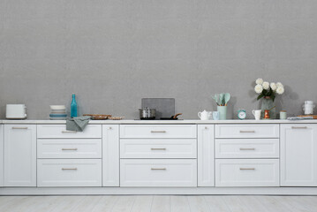 Stylish kitchen interior with grey wall. Space for text