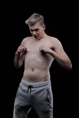 Fototapeta premium Young man posing in the dark in the studio