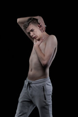 Naklejka premium Young man posing in the dark in the studio