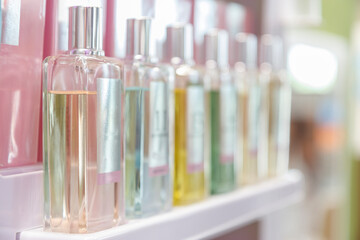 Close up on perfume bottles resting on a retailer shelf.