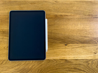 Minimalist Tablet with Stylus Pen On Wooden Table