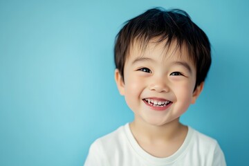 Cute Asian little kid smiling and feeling happy, isolated on blue background.