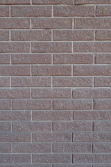 Uneven surface of pink split face brick veneer wall with stretcher bond pattern