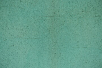 Cracked surface of dirty and faded turquoise painted wall