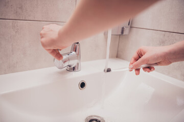 Cropped photo of girl hands arms preparing brushing teeth indoors house apartment washroom